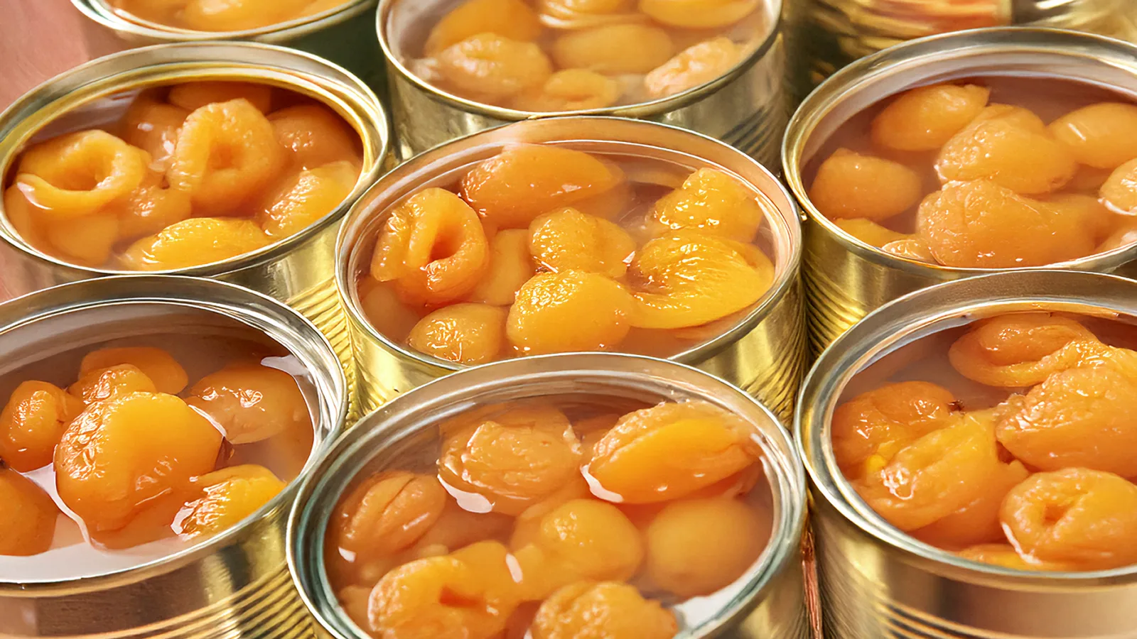 Mitades de duraznos en latas abiertas